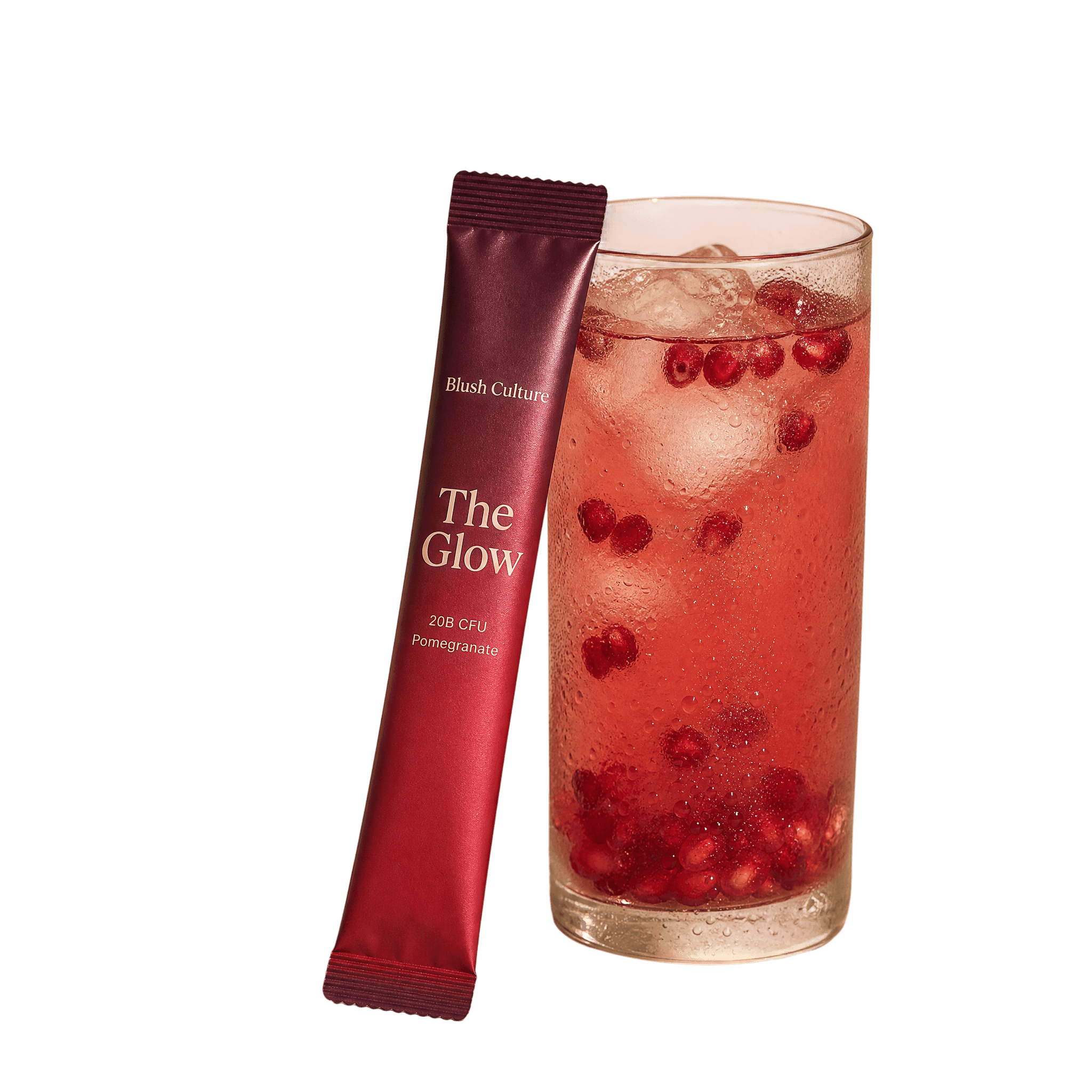 The Glow stirred into a tall glass of water, beside its stick pack